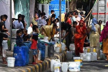 NEW DELHI, INDIA - 6 Haziran 2024 Yeni Delhi, Hindistan 'da 6 Haziran 2024 tarihinde Chanakyapuri' de bir belediye tankerinden su topladı. Perşembe günü Yüksek Mahkeme, Himachal Pradesh hükümetine 137 adet fazla su bulundurma yasağı getirdi.