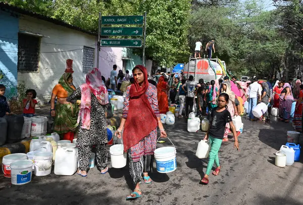 NEW DELHI, INDIA - 6 Haziran 2024 Yeni Delhi, Hindistan 'da 6 Haziran 2024 tarihinde Chanakyapuri' de bir belediye tankerinden su topladı. Perşembe günü Yüksek Mahkeme, Himachal Pradesh hükümetine 137 adet fazla su bulundurma yasağı getirdi.