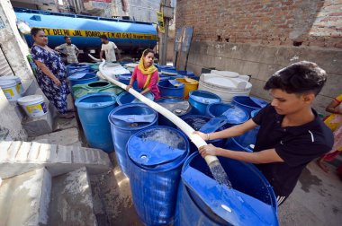 NEW DELHI, INDIA 9 Haziran 2024 Sangam Vihar 'daki yüksek sıcaklık dalgası sırasında Delhi Hükümeti' nin ikmal su tankerinden su dolduran insanlar 9 Haziran 2024 tarihinde Yeni Delhi, Hindistan 'da. (Fotoğraf: Sanjeev Verma / Hindustan Times 