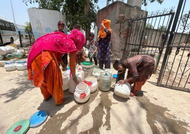 GURUGRAM INDIA 12 Haziran 2024 Evsiz insanlar 12 Haziran 2024 'te Gurugram Hindistan' da Tau Devi Lal Stadyumu yakınlarındaki Rajiv 'de sıcak bir yaz günü sıcak bir hava dalgasının ortasında hükümetin musluklarından su dolduruyorlar. Fotoğraf: Parveen Kumar / Hindusta