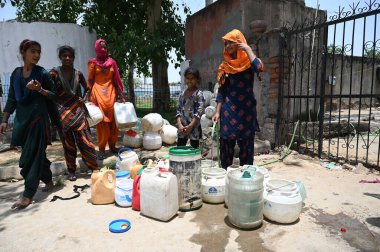 GURUGRAM INDIA 12 Haziran 2024 Evsiz insanlar 12 Haziran 2024 'te Gurugram Hindistan' da Tau Devi Lal Stadyumu yakınlarındaki Rajiv 'de sıcak bir yaz günü sıcak bir hava dalgasının ortasında hükümetin musluklarından su dolduruyorlar. Fotoğraf: Parveen Kumar / Hindusta