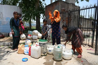 GURUGRAM INDIA 12 Haziran 2024 Evsiz insanlar 12 Haziran 2024 'te Gurugram Hindistan' da Tau Devi Lal Stadyumu yakınlarındaki Rajiv 'de sıcak bir yaz günü sıcak bir hava dalgasının ortasında hükümetin musluklarından su dolduruyorlar. Fotoğraf: Parveen Kumar / Hindusta