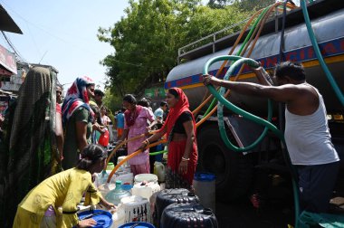 NEW DELHI INDIA 12 Haziran 2024 İnsanlar 12 Haziran 2024 tarihinde Yeni Delhi Hindistan 'da devam eden sıcak yaz havası sırasında Chanakyapuri Delhi' deki bir NDMC su tankerinden plastik su dolduruyorlar. Fotoğraf: Salman Ali / H
