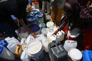NEW DELHI INDIA 12 Haziran 2024 İnsanlar 12 Haziran 2024 tarihinde Yeni Delhi Hindistan 'da devam eden sıcak yaz havası sırasında Chanakyapuri Delhi' deki bir NDMC su tankerinden plastik su dolduruyorlar. Fotoğraf: Salman Ali / H
