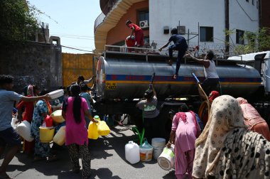NEW DELHI INDIA 12 Haziran 2024 İnsanlar 12 Haziran 2024 tarihinde Yeni Delhi Hindistan 'da devam eden sıcak yaz havası sırasında Chanakyapuri Delhi' deki bir NDMC su tankerinden plastik su dolduruyorlar. Fotoğraf: Salman Ali / H