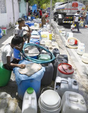 NEW DELHI INDIA JUNE 12 2024    Residents of Vivekanand Camp sits near water containers as they wait for water tanker at Chanakyapuri on June 12 2024 in New Delhi India.  Photo by Sanjeev Verma/Hindustan Times   clipart