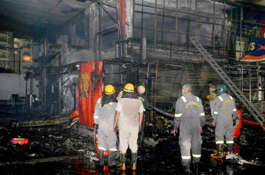 NOIDA INDIA 12 Haziran 2024 itfaiye personeli Noida Hindistan 'da 12 Haziran 2024 tarihinde 37. bölgedeki benzin pompasının yanındaki dükkandaki yangını söndürdü. İki saat aralıksız ateş püskürtüldükten sonra on kadar ihale hızla oraya gider ve alevleri söndürür.
