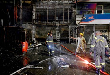 NOIDA INDIA 12 Haziran 2024 itfaiye personeli Noida Hindistan 'da 12 Haziran 2024 tarihinde 37. bölgedeki benzin pompasının yanındaki dükkandaki yangını söndürdü. İki saat aralıksız ateş püskürtüldükten sonra on kadar ihale hızla oraya gider ve alevleri söndürür.