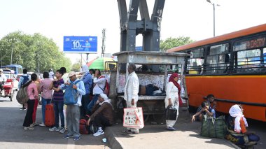 NEW DELHI INDIA 13 Haziran 2024 DTC Yolcuları 13 Haziran 2024 tarihinde Yeni Delhi Hindistan 'da, Minto Yolu yakınlarındaki Ajmeri Gate tren istasyonunda, sıcak bir yaz öğleden sonra köprü üstü gölgesi altında duruyorlar. Fotoğraf: Sonu Mehta / Hindustan Times 