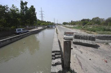 NEW DELHI INDIA 13 Haziran 2024 Delhi polis memurları 13 Haziran 2024 tarihinde Yeni Delhi Hindistan 'da Khera Kalan' da Munak kanalı boyunca devriye geziyorlar. Polis personelinin kanal boyunca konuşlandırılması, Çarşamba günü Yüksek Mahkeme 'nin doğrudan bir bağlantı iddiasına girmesi sonrasında gerçekleşti.