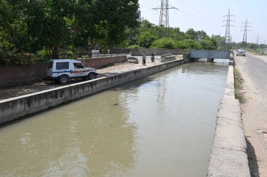 NEW DELHI INDIA 13 Haziran 2024 Delhi polis memurları 13 Haziran 2024 tarihinde Yeni Delhi Hindistan 'da Khera Kalan' da Munak kanalı boyunca devriye geziyorlar. Polis personelinin kanal boyunca konuşlandırılması, Çarşamba günü Yüksek Mahkeme 'nin doğrudan bir bağlantı iddiasına girmesi sonrasında gerçekleşti.