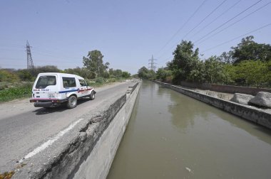 NEW DELHI INDIA 13 Haziran 2024 Delhi polis memurları 13 Haziran 2024 tarihinde Yeni Delhi Hindistan 'da Khera Kalan' da Munak kanalı boyunca devriye geziyorlar. Polis personelinin kanal boyunca konuşlandırılması, Çarşamba günü Yüksek Mahkeme 'nin doğrudan bir bağlantı iddiasına girmesi sonrasında gerçekleşti.