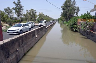 NEW DELHI INDIA 13 Haziran 2024 Delhi polis memurları 13 Haziran 2024 tarihinde Yeni Delhi Hindistan 'da Harevali' de Munak kanalı boyunca devriye geziyorlar. Kanal boyunca polis personelinin görevlendirilmesi, Çarşamba günü Yüksek Mahkeme 'nin aralarında doğrudan bir bağlantı kurması sonrasında gerçekleşti.