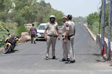 NEW DELHI INDIA 13 Haziran 2024 Delhi polis memurları Munak kanalı Bawana JJ Kolonisi üzerinden 13 Haziran 2024 tarihinde Yeni Delhi Hindistan 'da Harevali' ye devriye geziyorlar. Kanal boyunca polis personelinin görevlendirilmesi, Çarşamba günü Yüksek Mahkeme 'den sonra geldi.