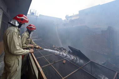 NEW DELHI, INDIA: JUNE 14, 2024 - Firefighters seen during cooling off operations on second day after a fire broke out inside old Katra Marwadi Market of Chandni Chowk at Nai Sadak on June 14 2024 in New Delhi, India.  clipart