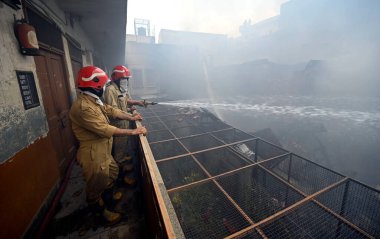 NEW DELHI: 14 Haziran 2024 - Chandni Chowk 'un eski Katra Marwadi Pazarı' nda 14 Haziran 2024 'te Yeni Delhi, Hindistan' da çıkan yangının ardından soğutma operasyonları sırasında görülen itfaiyeciler. 
