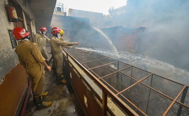 NEW DELHI: 14 Haziran 2024 - Chandni Chowk 'un eski Katra Marwadi Pazarı' nda 14 Haziran 2024 'te Yeni Delhi, Hindistan' da çıkan yangının ardından soğutma operasyonları sırasında görülen itfaiyeciler. 