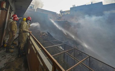 NEW DELHI, INDIA: JUNE 14, 2024 - Firefighters seen during cooling off operations on second day after a fire broke out inside old Katra Marwadi Market of Chandni Chowk at Nai Sadak on June 14 2024 in New Delhi, India.  clipart