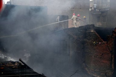 NEW DELHI, INDIA: JUNE 14, 2024 - Firefighters seen during cooling off operations on second day after a fire broke out inside old Katra Marwadi Market of Chandni Chowk at Nai Sadak on June 14 2024 in New Delhi, India.  clipart