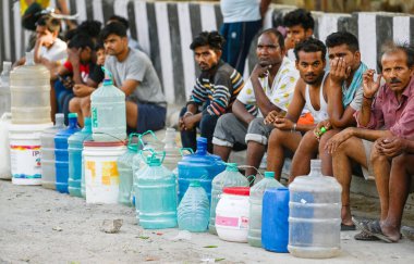 NEW DELHI, INDIA: 14 Haziran 2024 - 14 Haziran 2024 tarihinde Hindistan 'ın Yeni Delhi kentinde Mayur Vihar yakınlarında su tankerleri beklerken görülen Chilla Village sakinleri.