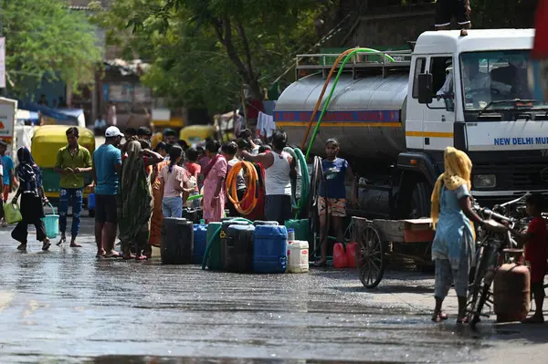 NEW DELHI INDIA 12 Haziran 2024 İnsanlar 12 Haziran 2024 tarihinde Yeni Delhi Hindistan 'da devam eden sıcak yaz havası sırasında Chanakyapuri Delhi' deki bir NDMC su tankerinden gelen plastik kutuya su dolduruyorlar. Fotoğraf: Salman Ali / Hind