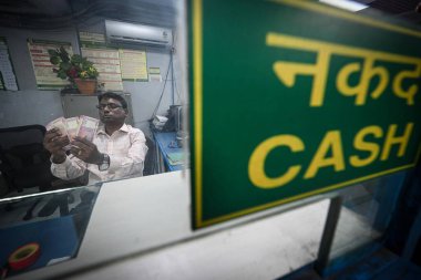 NEW DELHI INDIA 23 Mayıs 2023 Rs RBI tiraj ve döviz penceresinden 2000 Rupi çekildiğini duyurduktan sonra bir kasiyer Yeni Delhi 'de 23 Mayıs 2023 tarihinde Sa