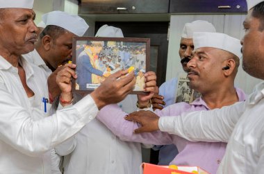 MUMBAI INDIA 6 Mayıs 2023 Mumbai dabbawalas kutlamalarında Prens Charles 'ın Westminster Manastırı' nda düzenlenen taç giyme töreninde İngiltere 'nin 40. hükümdarı olarak taç giymesi üzerine birbirlerine tatlı yedirdiler.