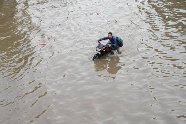 NEW DELHI, INDIA - 23 Ağustos 2024: Banliyö sakinleri, 23 Ağustos 2024 tarihinde Hindistan 'ın Yeni Delhi kentinde, yoğun yağmurdan sonra, Dhaula Kuan üstgeçidi yakınlarındaki su dolu yollarda yürüdüler.
