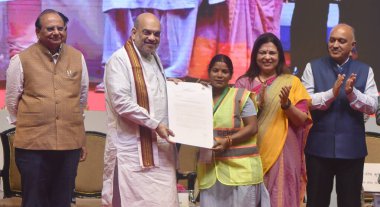 NEW DELHI INDIA MAY 3 2023 Union Home Minister Amit Shah Delhi LG Vinai Kumar Saxena and MOS for External Affairs Meenakshi Lekhi during the present the appointment letters to a NDMC staff at Talkatora Indoor Stadium on May 3 2023 in New Delhi India  clipart