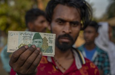 MUMBAI INDIA MAYIS 16 2023 Vilas Kondhari üç buçuk yıl sonra Pakistan 'dan dönen balıkçı, Mumbai Ahmedabad Otoyolu, Palghar' daki Aamgaon 'daki Pakistan Edhi Vakfı' ndan 5000 Rupi 'lik banknot aldığını gösteriyor. 