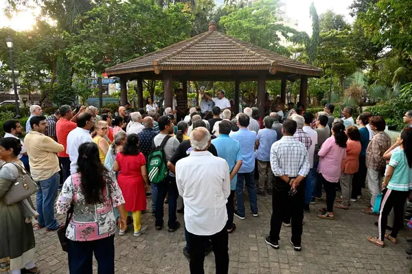 stock image MUMBAI INDIA MAY 27 2023 Residents near Sadhu Vaswani Garden gather for a meeting inside against Metro Station outside the garden at Bandra on May 27 2023 in Mumbai India Photo by Vijay Bate Hindustan Times 