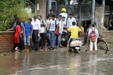 GURUGRAM INDIA 27 Mayıs 2023 İnsanlar, 27 Mayıs 2023 'te Hindistan Gurugramı' nda Parveen Kumar Hindustan Times tarafından çekilen fotoğraf ile Narsinghpur köyündeki işyerlerine gitmek için suya bulanmış bir alanı geçtiler. 