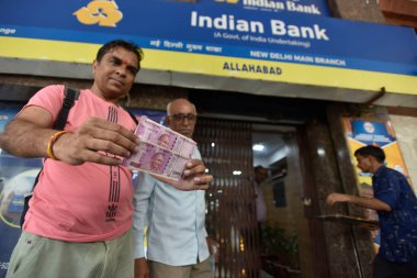 YENİ DELHI INDIA 23 MAYIS 2023 Bir adam CP 'de 23 Mayıs 2023 tarihinde Hint bankasının dışında değiştirilmeden önce 2000 Rupi tutuyor Hindistan rezerv bankası piyasadan 2000 Rupi çekildiğini ve varolduğunu duyurdu