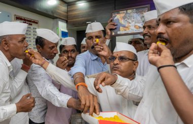 MUMBAI INDIA MAY 6 2023 Mumbai dabbawalas feed sweets to one another in celebration after Prince Charles was crowned as King Charles III as the 40th monarch of Britain during a coronation ceremony at Westminster Abbey in a central London church at th clipart