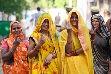 LUCKnow INDIA MAYIS 4 2023 Köy kadınları, 4 Mayıs 2023 tarihinde Lucknow Hindistan 'da yapılan Malhaur sandık kulübesinde yapılan yerel seçimler sırasında oylarını kullandıktan sonra dövmeli parmaklarını masadan çıkarken gösteriyor. 