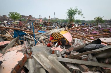YENİ DELHI INDIA MAYIS 12023 YÖNETİ Yıkılmış yapılardan değerli eşyalarını çıkarırken, YASI ve bölge yönetiminin Tughlaqabad Kalesi yakınlarındaki yasadışı yapıları yıkmak için 1 Mayıs 2023 tarihinde Yeni Delhi Ind 'de yürüttüğü görülüyor.