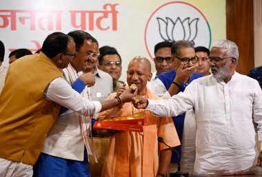 LUCKNOW INDIA MAY 13 2023 Deputy Chief minister Keshav Prasad Maurya and Brajesh Pathak and cabinet minister Swatantra Dev Singh exchanging sweets with CM Yogi Adityanath at BJP party office after BJP s massive victory in Local bodies on May 13 2023  clipart