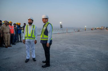 MUMBAI INDIA MAY 24 2023 Chief Minister Eknath Shinde and DCM Devendra Fadnavis flag off a bus on a short distance on the newly completed Mumbai Trans Harbour Link MTHL on May 24 2023 in Mumbai India The link will be the longest sea bridge in India T clipart