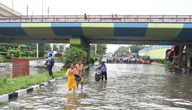 NEW DELHI INDIA 23 AĞUSTOS 2024 Banliyö sakinleri, Sonu Mehta Hindustan Times 'ın şiddetli yağmurdan sonra Dhaula Kuan üstgeçidi yakınlarındaki sulak yollarda yürüdüler. 