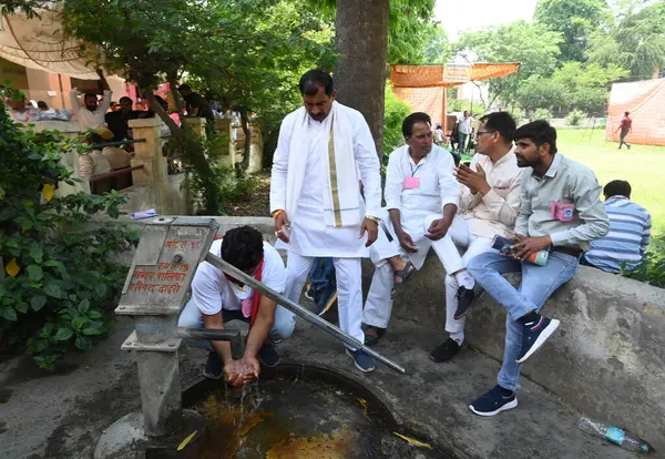 stock image GREATER NOIDA INDIA MAY 13 2023 Polling agent drinking water from hand pump in scorching heat at Mihir Bhoj PG College in Dadri on May 13 2023 in Greater Noida India The Bhartiya Janata Party swept the Uttar Pradesh local body polls as it won all 17 