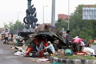 NEW DELHI INDIA JUNE 1 2023 Families taking shelter next to the demolished makeshifts after an anti encroachment drive being carried near Pragati Maidan by PWD at Bhairon Marg clipart