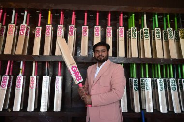 SRINAGAR INDIA JUNE 12 2023 Fawzul Kabir the owner of a GR8 cricket bat manufacturing unit displays a bat on June 12 2023 in Srinagar India GR8 bat manufacturers have received an order for bats to be used during the 2023 One Day International ODI Wor clipart