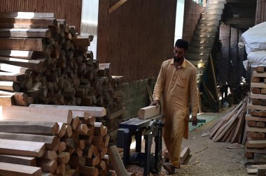 SRINAGAR INDIA JUNE 12 2023 A laborer works in a GR8 cricket bat manufacturing unit in Sangam some 38 kilometers south of Srinagar on June 12 2023 in Srinagar India GR8 bat manufacturers have received an order for bats to be used during the 2023 One  clipart