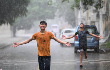 NEW DELHI INDIA JUNE 16 2023 Children enjoying amid heavy rain at near Mandi House on June 16 2023 in New Delhi India The India Meteorological Department had predicted light rain with gusty winds in Delhi NCR on Thursday According to the weather depa clipart