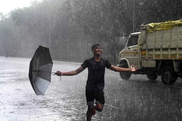 stock image NEW DELHI INDIA JUNE 16 2023 A boy enjoying amid heavy rain at Bhagwan Dass road near Mandi House on June 16 2023 in New Delhi India The India Meteorological Department had predicted light rain with gusty winds in Delhi NCR on Thursday According to t