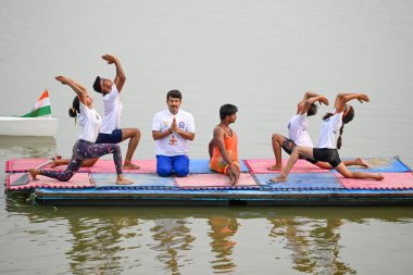 NEW DELHI INDIA 21 Haziran 2023 Manoj Tiwari Parlamento Üyesi, Sanchit K tarafından Yeni Delhi Hindistan 'da 21 Haziran 2023 tarihinde düzenlenen Uluslararası Yoga Günü vesilesiyle Yamuna Nehri üzerinde Sonia Vihar Su Sporları Kulübü öğrencileriyle birlikte Yoga yapıyor.