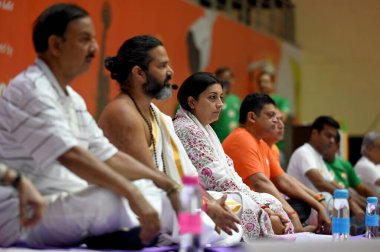 NOIDA INDIA JUNE 21 2023 Minister of Women and Child Development MP Amethi Lok Sabha Constituency Smriti Irani and GBN MP Dr Mahesh Sharma performs yoga on International Yoga Day at Noida indoor Stadium Sector 21 A on June 21 2023 in Noida India Phot clipart