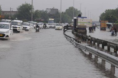 GURUGRAM INDIA JUNE 25 2023 Vehicle drive through a waterlogged stretch after heavy rains at National Highway 48 near Khandsa village on June 25 2023 in Gurugram India Heavy rainfall accompanied by lightning lashed several parts of the national capit clipart