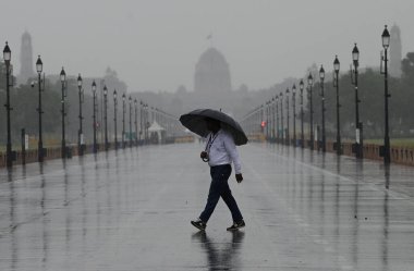 19 Haziran 2023 'te Yeni Delhi Hindistan' da 19 Haziran 2023 'te hafif sağanak yağış sırasında Hindistan Kapısı yakınlarında yürüyen bir adam 24 saat boyunca 5 mm yağmur yağdı ve pazartesi sabah 08.30' da sona erdi.