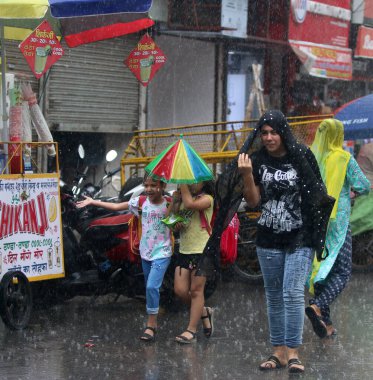 NEW DELHI INDIA 19 HAZİRAN 2023 19 Haziran 2023 Bir öğleden sonra Jangpura bölgesinde yağmur sırasında sokaklardan geçen insanlar 19 Haziran 2023 'te Yeni Delhi Hindistan' da 24 saat boyunca 5 mm yağmur yağdı.